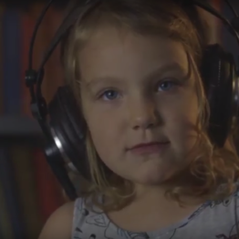 Music video for Truth, by Frank Deresti and the Lake Effect. Image shows a girl with inquisitive eyes wearing headphones.